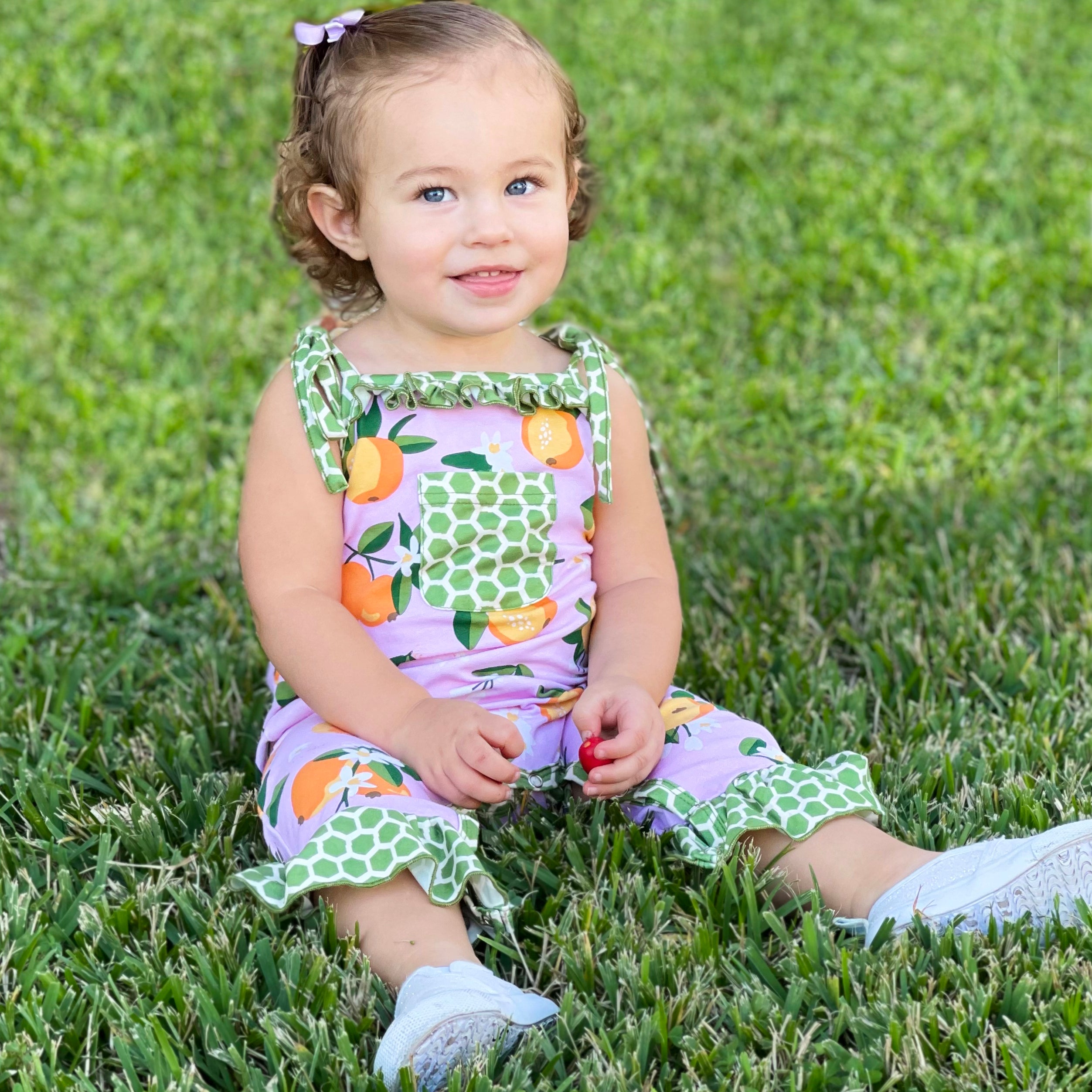 AnnLoren Pink Peach Baby Toddler Girls Spring Romper with green polka dot pocket and ruffle trim, perfect for spring outings.